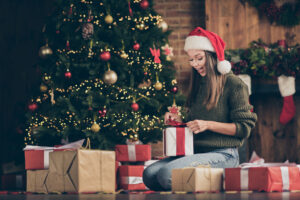 Donna scarta i regali sotto l'albero